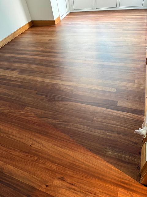 Tarima de madera barnizada en una habitación, vista de cerca