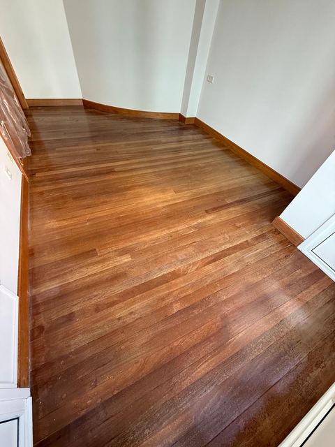Habitación con suelo de tarima barnizado y rodapié de madera