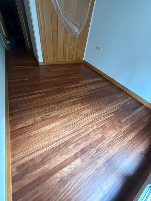 Habitación con tarima barnizada y armario empotrado de madera