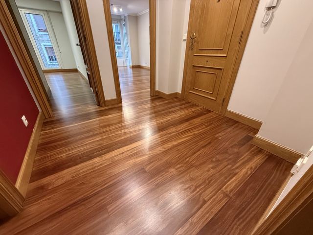 Recibidor con suelo de madera barnizado y puertas de madera